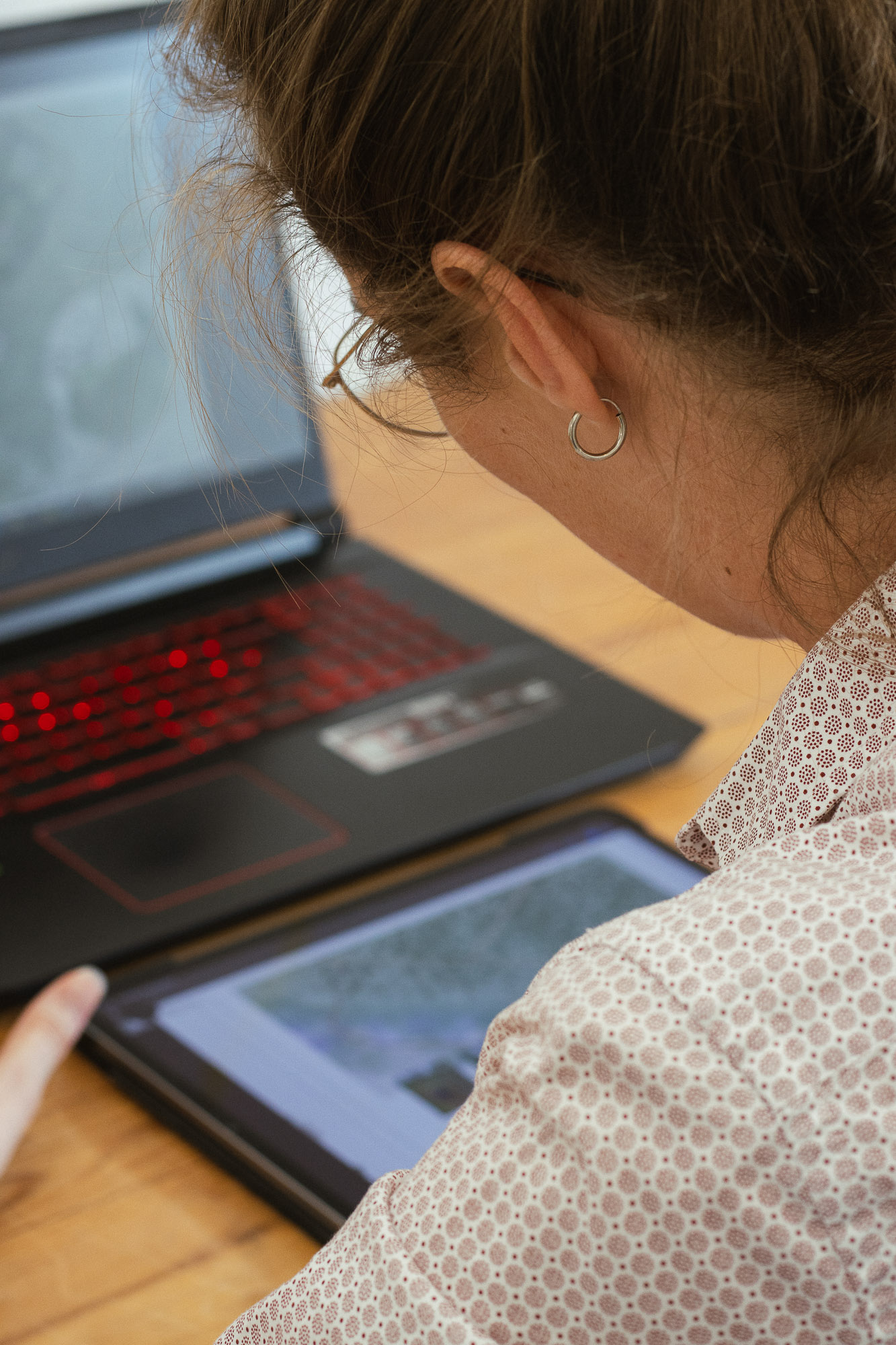 Célestine Merckx de dos travaillant sur sa tablette graphique à coté de son PC